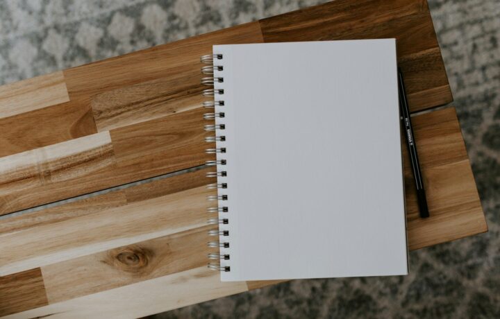 Cuaderno abierto sobre una mesa de madera para planificar artículos